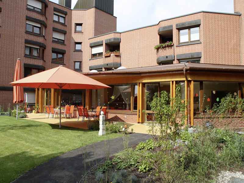 Die sonnige Terrasse und das Gebäude des Kinderhaus AtemReich