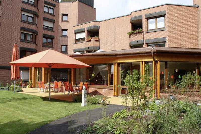 Die sonnige Terrasse und das Gebäude des Kinderhaus AtemReich