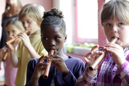 Kinder spielen in ihrem Klassenzimmer Blockflöte