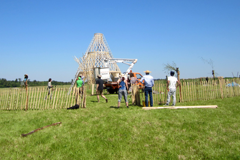 A crane puts up the upper part of the sculpture