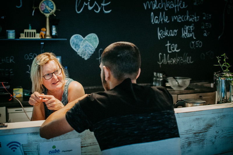 Mitarbeiterin und Jugendlicher im Café