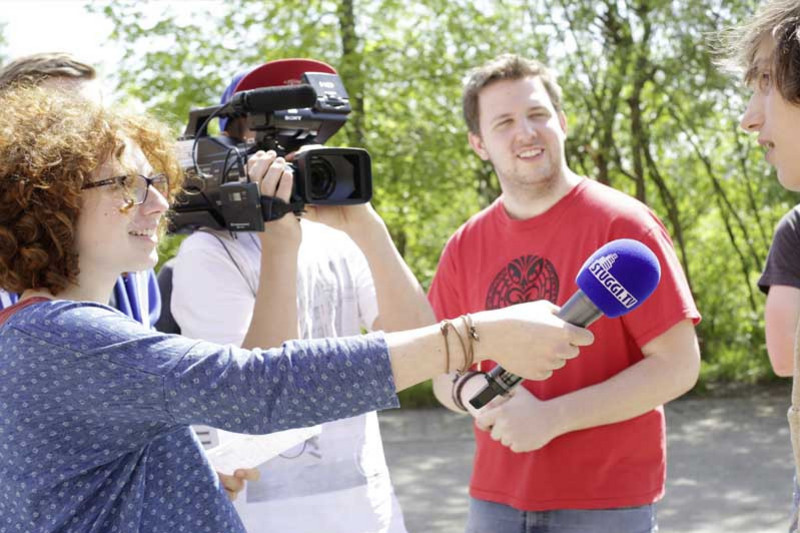 Youths with microphone and camera working on a media project for school