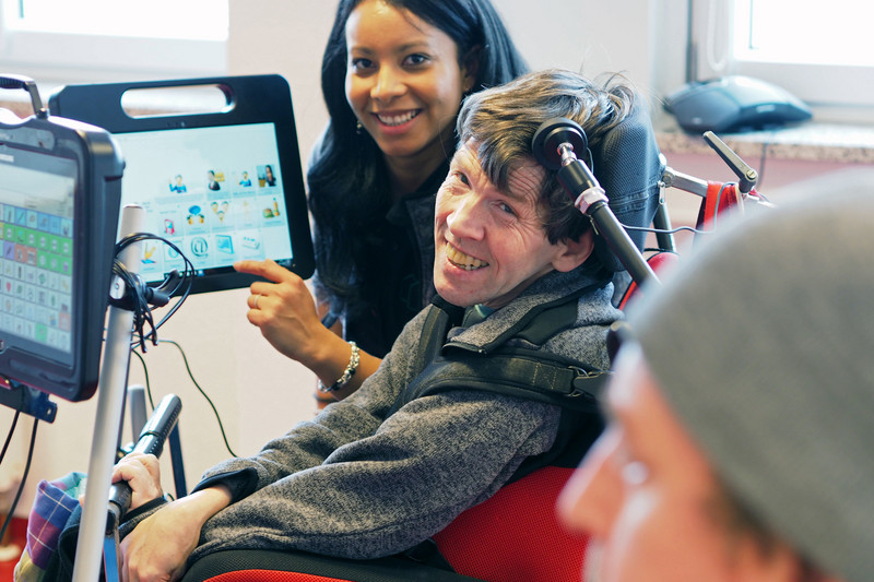 Man in a wheelchair with assistant