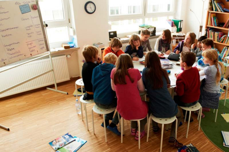 Pupils sitting around a table, learning together