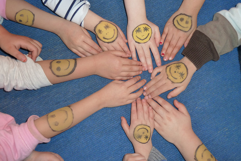 Children's hands painted with smileys
