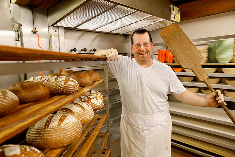 Man with bread shooter in the bakery
