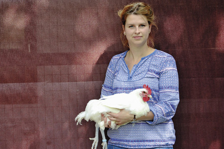 Inga Günther, Geschäftsführerin Ökotierzucht mit einem weißen Huhn auf dem Arm