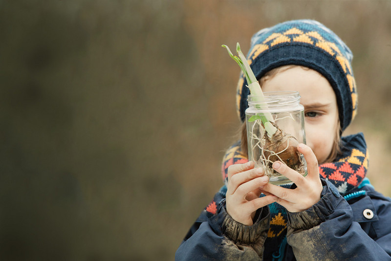 Child with tulip in a disposable glass