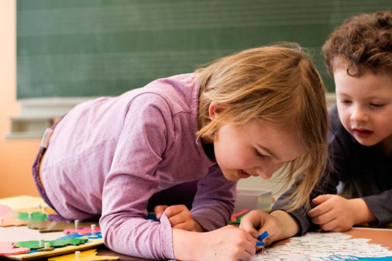 Young pupils working with an educational puzzle