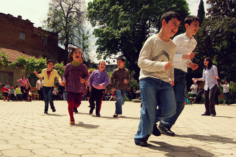 Boys and girls run and play happily on the schoolyard