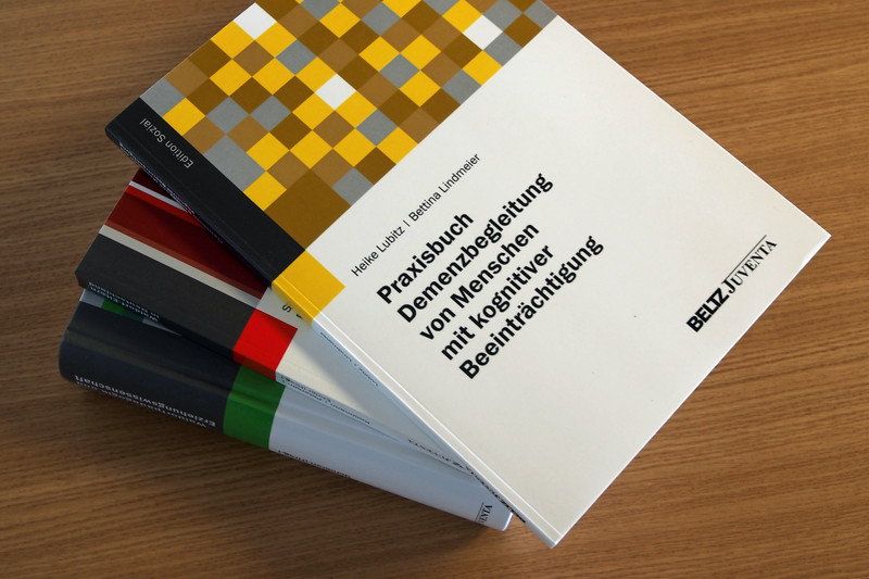 Pile of books with handbook on demetia care on top