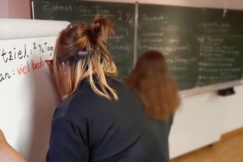 Auszubildende an Flipchart und Tafel