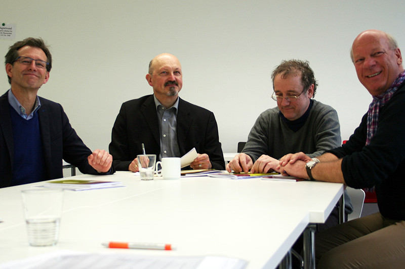 The four discussion participants sitting around a table