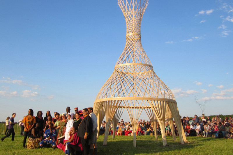 Gruppenfoto der Teilnehmer in der Abendsonne vor der Skulptur