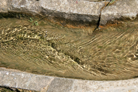 Wasser fließt durch eine steinerne Rinne
