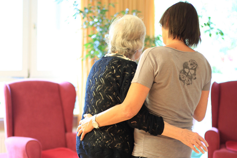 Younger woman supports older woman