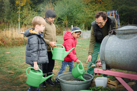 Kinder mit Gießkannen im Grünen Klassenzimmer
