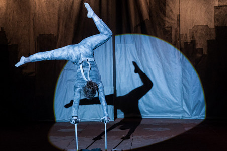 A young artist doing an handstand under the Big Top
