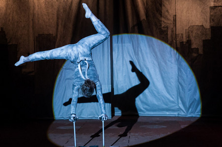 Ein junger Akrobat beim Handstand in der Manege