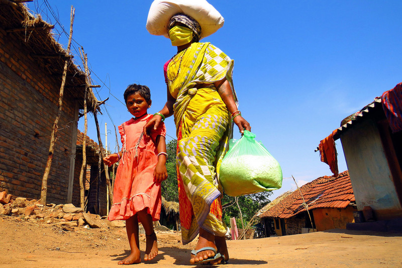 Mutter mit Maske und Kind in den indischen Slums