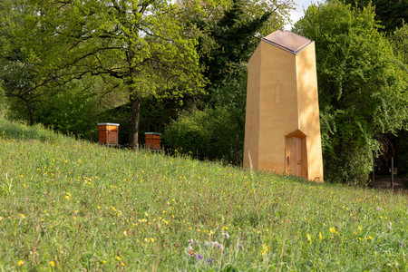 Bienenturm mit Bienenkästen auf der grünen Wiese