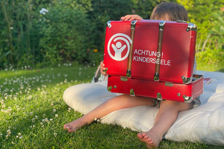 Foto: Kind mit Koffer