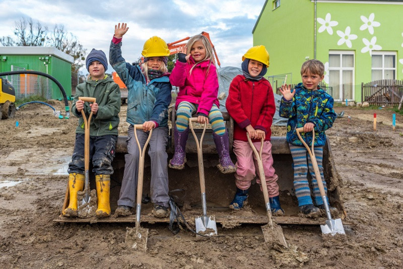 Children with spades on the construction site