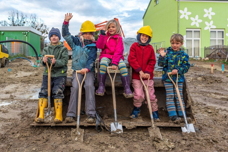 Kinder mit Spaten auf der Baustelle